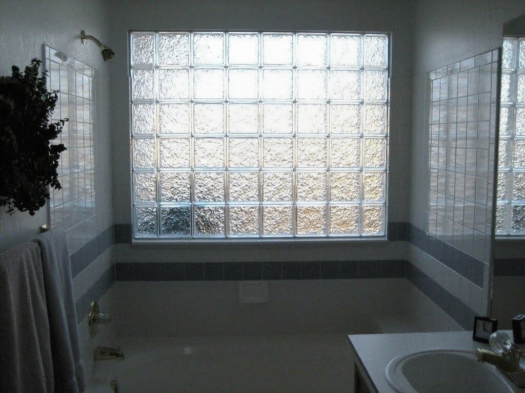Textured icescape glass block window above a bathtub, glowing with soft daylight