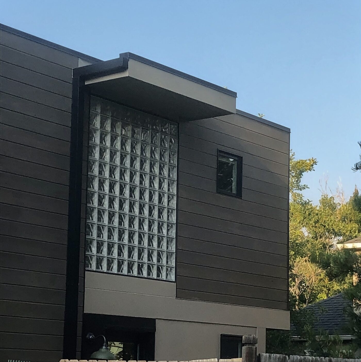 Tall vertical glass block window feature on a dark modern home exterior